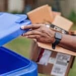 Man placing cardboard in recycling bin