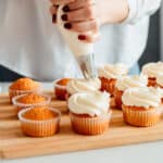 baker piping icing on baking cups