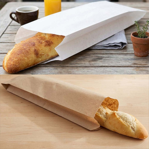 white paper bread bag on a table above a kraft paper bread bag on a counter